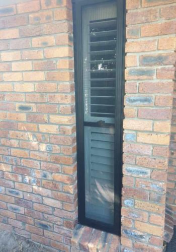Tall Shutter Window in Brick Wall — Security Screen Doors in Sunshine Coast, QLD