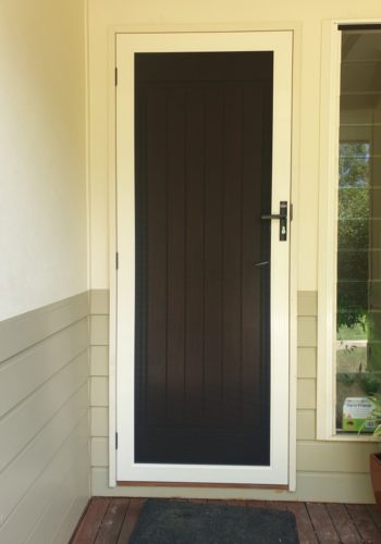 Invisi-Gard White stainless steel hinged security screen door installed on the front entrance of a Sunshine Coast home