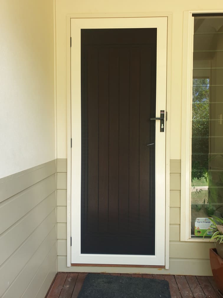 White stainless steel hinged security screen door installed on the front entrance of a Sunshine Coast home