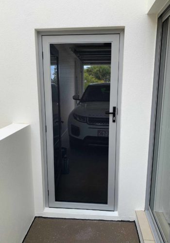 Invisi-Gard Grey Stainless Steel Hinged Door installed on a residental front door in the Sunshine Coast
