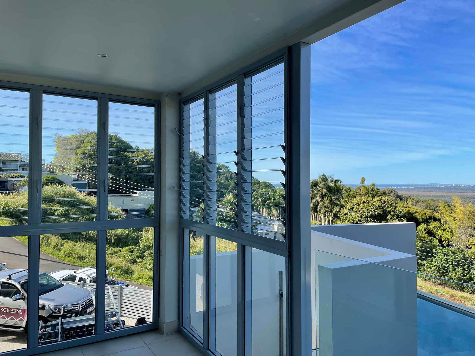 glass louvre window is installed on a balcony of a home in the Sunshine Coast